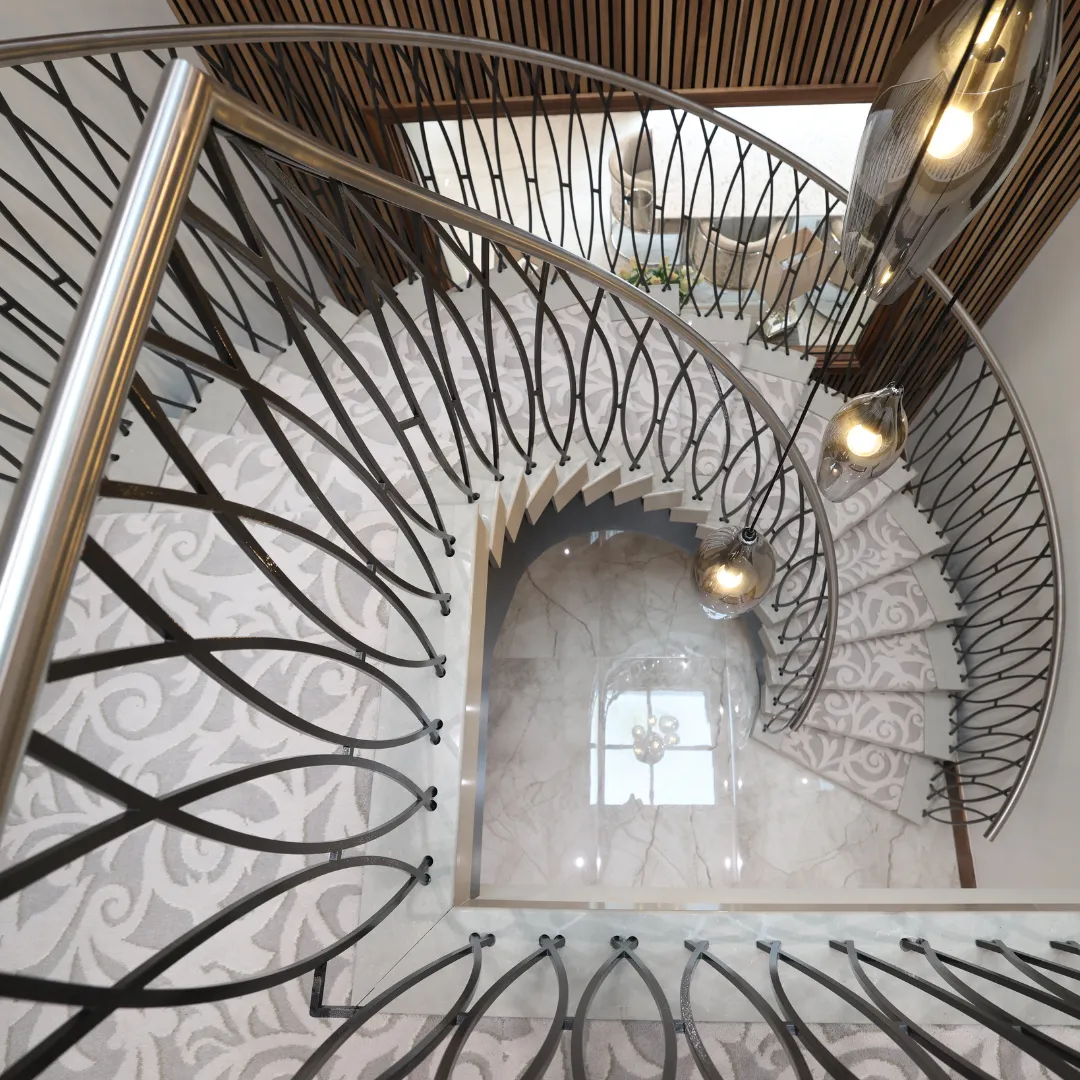 View looking down a curved staircase with patterned carpet, a curved metal balustrade and glass pendant lights