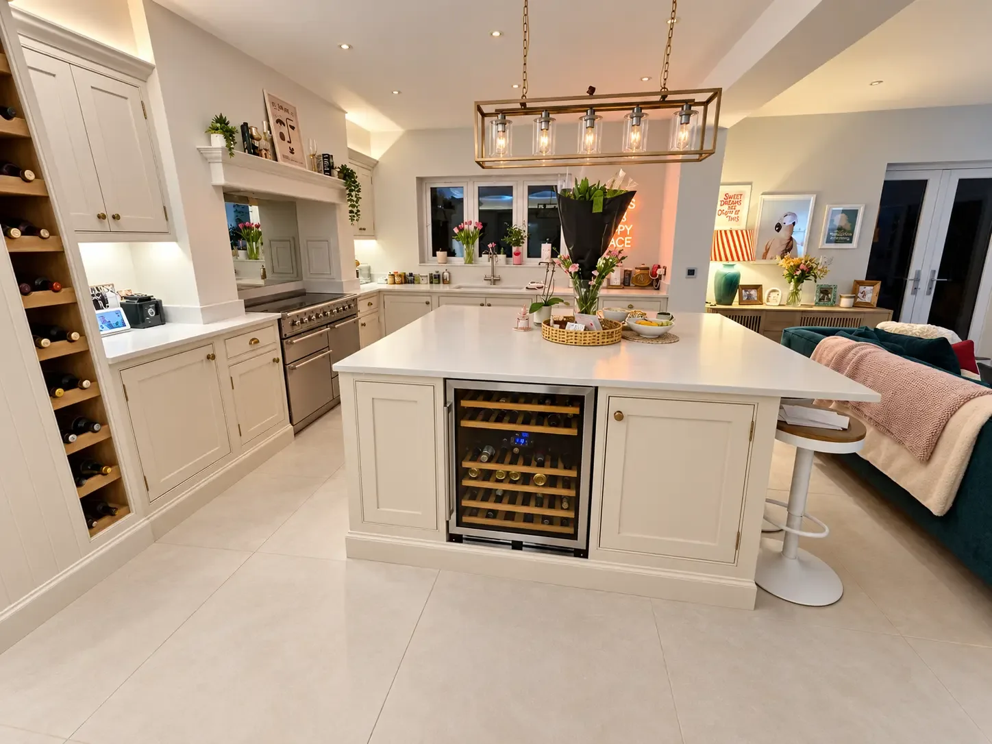 Kitchen island with an integrated wine fridge, built-in wine rack, range cooker and the open-plan living area beyond